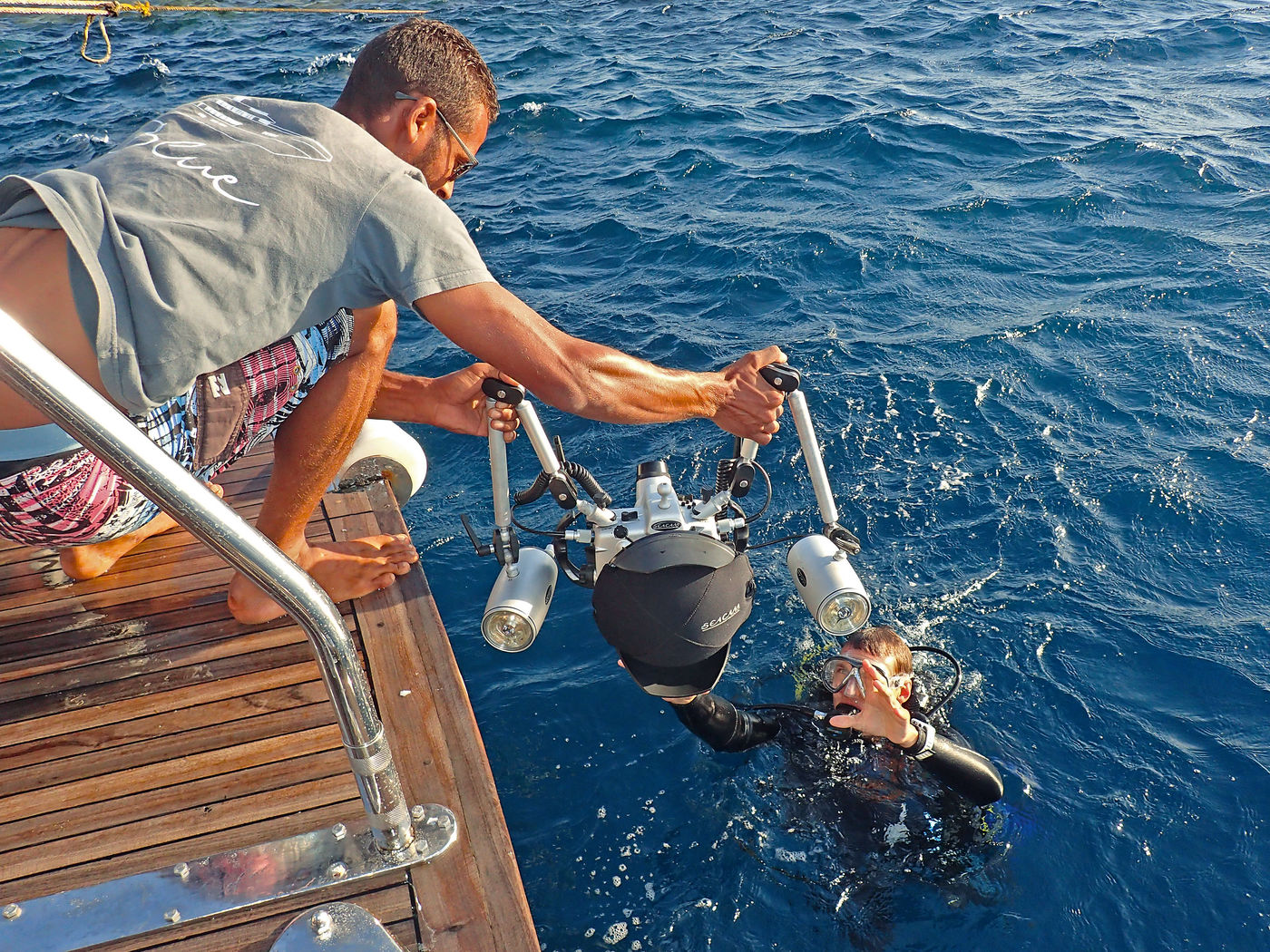 Anreichen lassen: Die Unterwasserkamera sollte man sich vom Schiff mit Domeportschutz anreichen lassen. Die Abdeckung kann man während des Tauchgangs ins Jacket stecken.