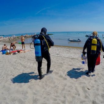 Vorbei an den Badegästen und ab ins Wasser: Als Taucher am Ostseestrand ist man immernoch eine Attraktion.