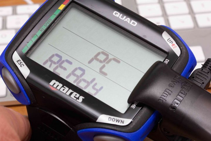 Mit einem zusätzlichen USB-Interface wird der Quad mit dem Rechner verbunden. Die Klammer greift seitlich und stellt auf der Rückseite des Gerätes einen zweipoligen Kontakt her. Geht man nun in den Übertragungsmodus des Tauchcomputers. Anschließend wählt man den Rechner in der App oder am Rechner aus und kann die Tauchgangsdaten übertragen.