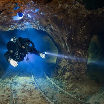 Höhlentaucher in der Opalmine in Slowakei mit Gegenlicht