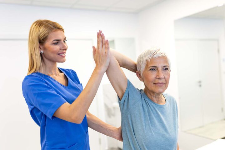 Physiotherapeutin unterstützt Patientin bei Übungen zur Schulter- und Beweglichkeitsrehabilitation