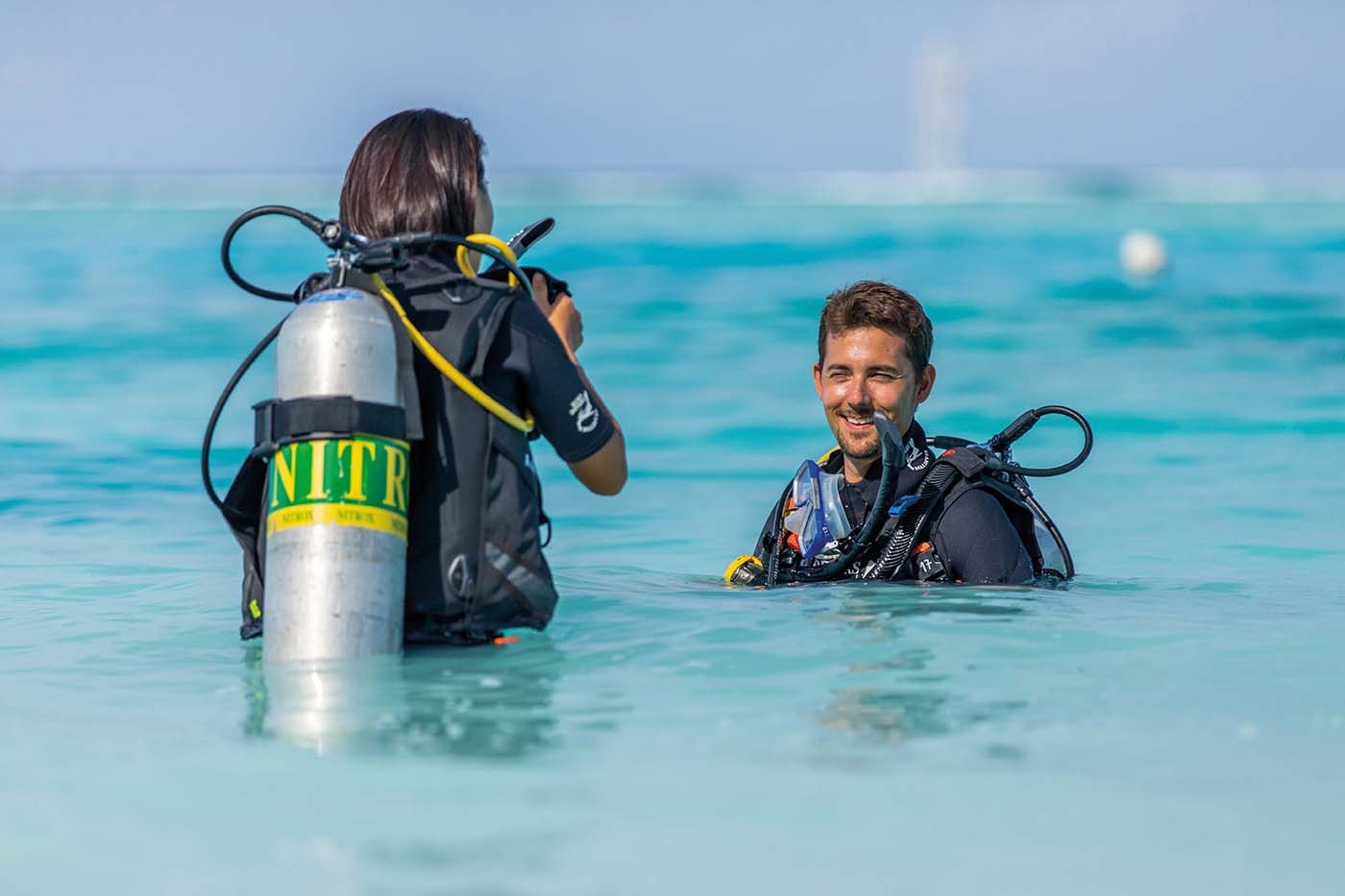 Euro-Divers-Tauchlehrer gibt einer Tauchschülerin eine Einweisung im flachen Wasser auf den Malediven