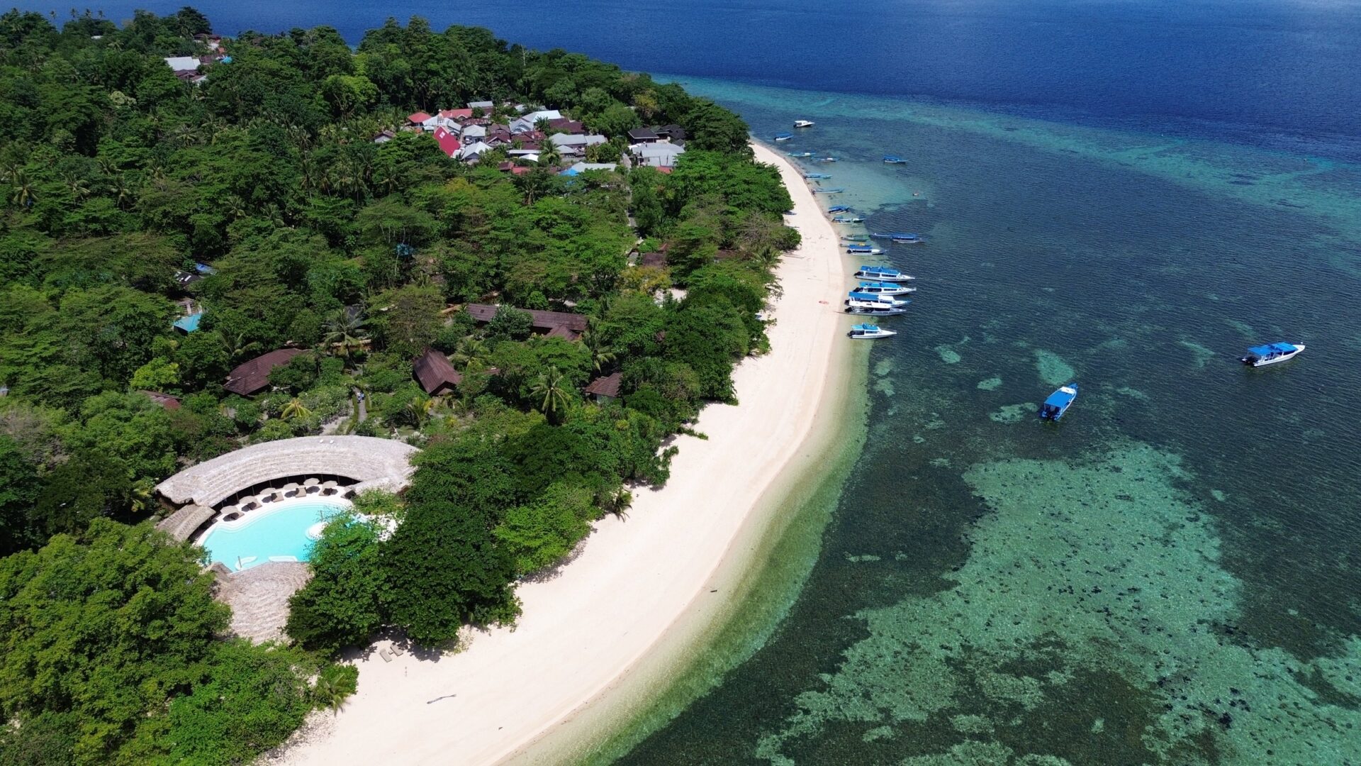 Luftaufnahme der Koralleninsel Siladen mit Strand, Siladen Resort & Spa und Riff im Bunaken-Nationalpark